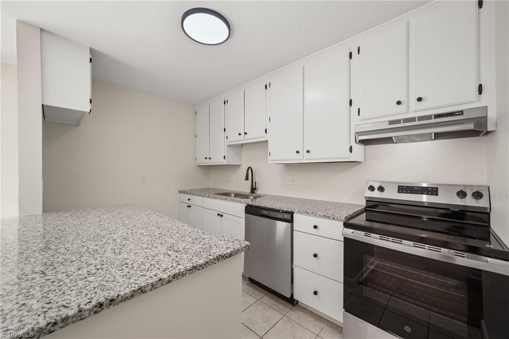Kitchen with white cabinets, granite countertops, and stainless-steel appliances.