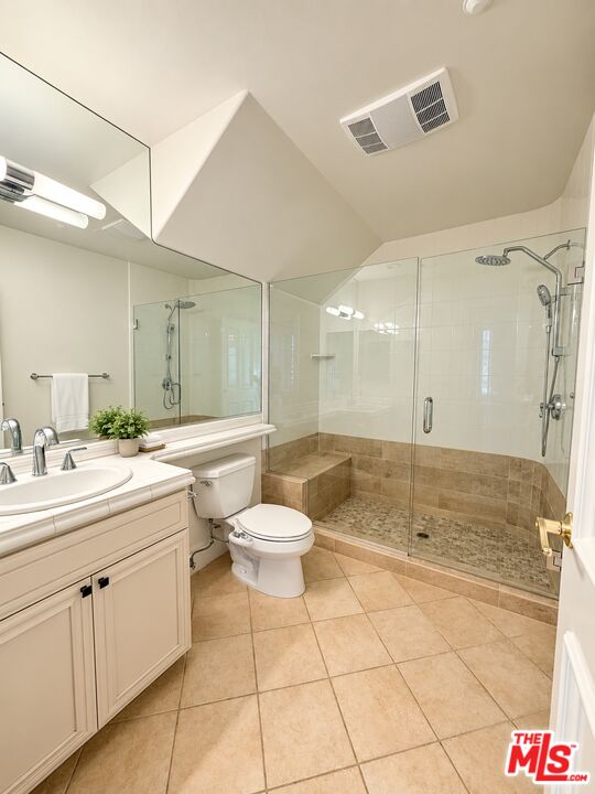 Bathroom with a cream vanity, large mirror, and glass-enclosed shower with a tiled bench.
