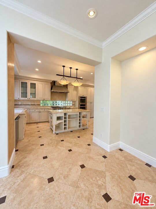 Kitchen with cream cabinetry, pendant lights, and a central island with open shelving.