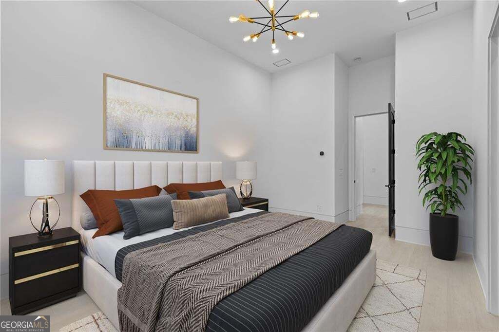Staged bedroom with a large bed, tall upholstered headboard, and potted plant beside the doorway.