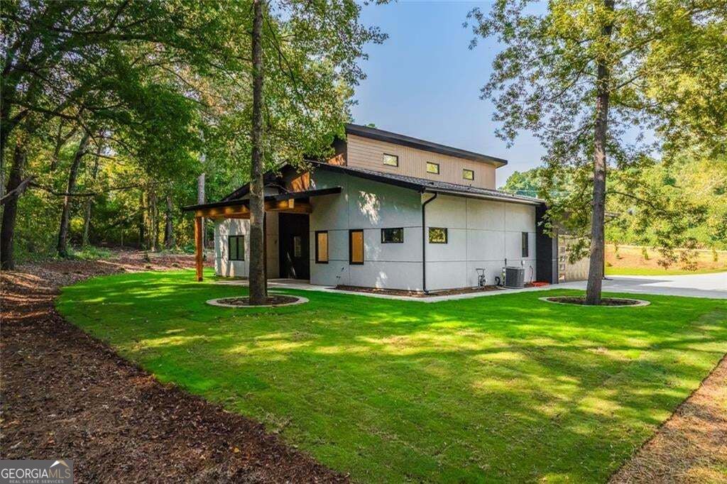 Modern two-story home with a covered entrance, broad lawn, and mature trees.