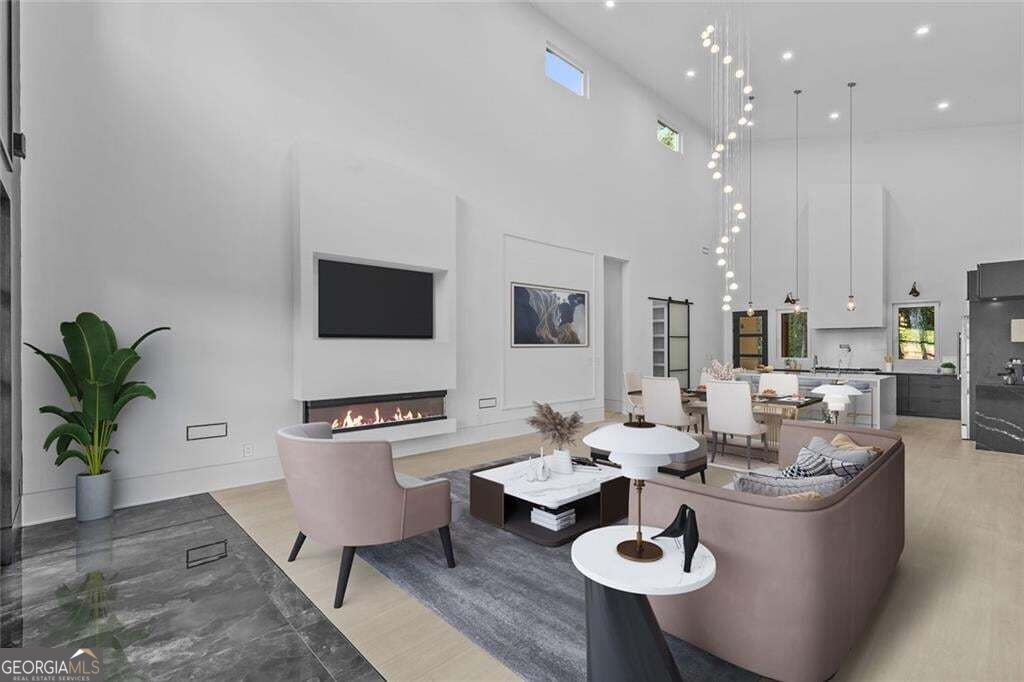 Vaulted living room with a modern fireplace, contemporary furnishings, and an open dining area and kitchen.