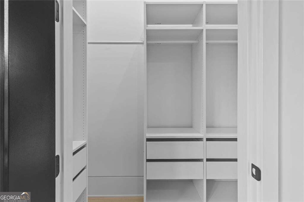 Built-in closet with white shelving, hanging space, and drawers.