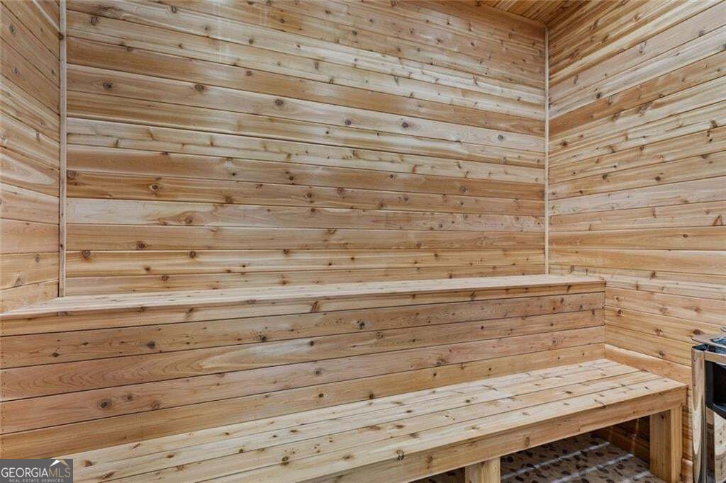 Wood-paneled sauna with tiered benches and a slatted floor.