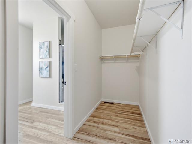 Empty walk-in closet with open shelving and hanging rods, viewed from the doorway.