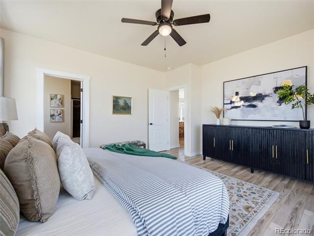 Furnished bedroom with striped bedding, a dark dresser, and large abstract wall art.