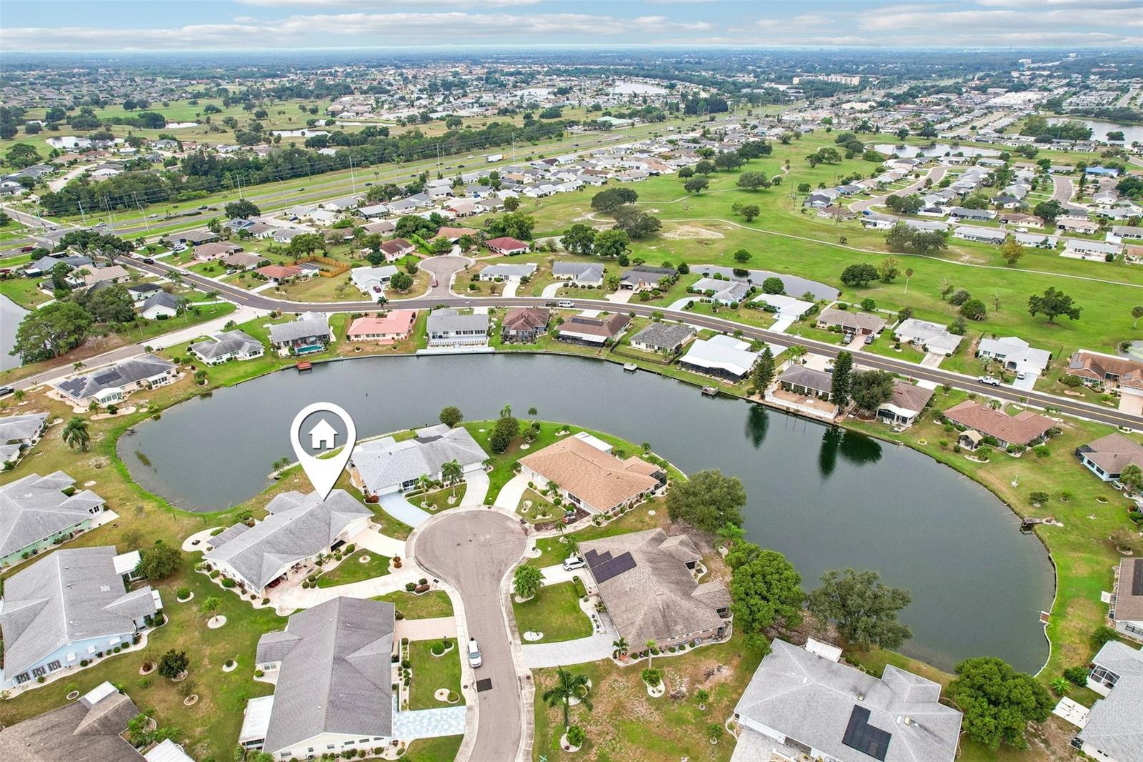 Aerial view of homes bordering a lake, with a marker highlighting one home.