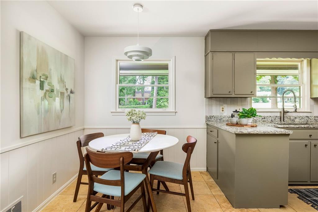Kitchen dining nook with a round table, wooden chairs, and taupe cabinetry.