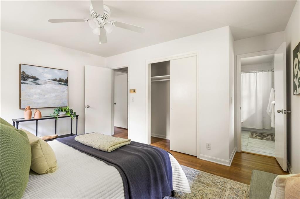 Bedroom with a neatly made bed, open closet, and adjoining bathroom.
