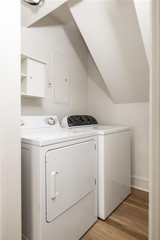 Laundry room with white washer and dryer beneath a sloped ceiling.