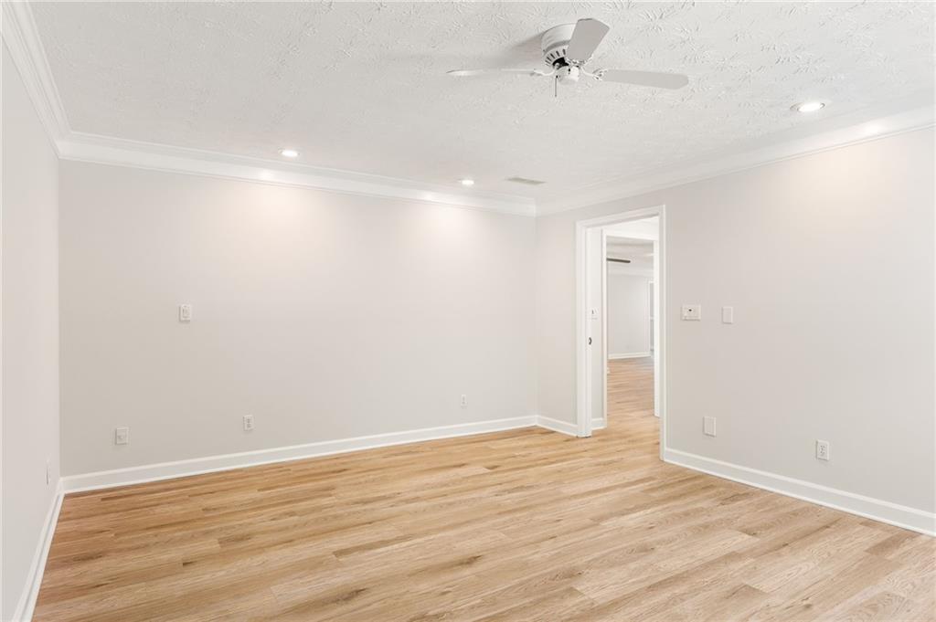 Empty room with light wood flooring, recessed lights, and a ceiling fan