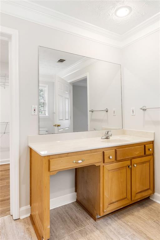 Bathroom with a wood vanity, white countertop, and large mirror.