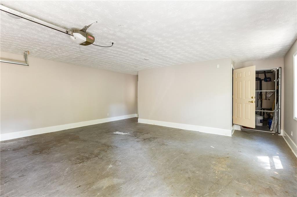 Empty garage with a concrete floor and an open storage area.