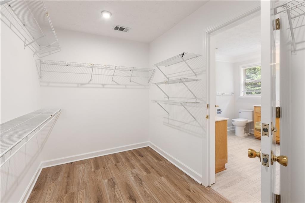 Walk-in closet with wraparound wire shelving and a doorway to the bathroom.