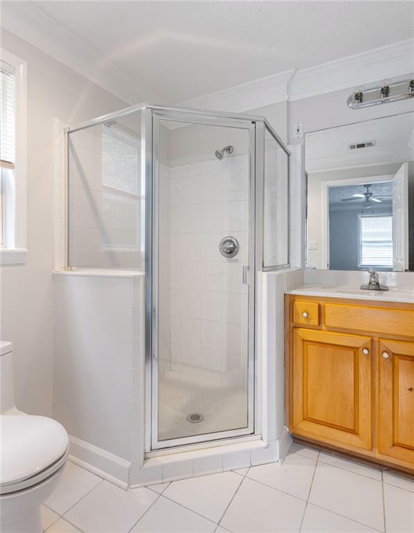 Bathroom with a glass corner shower and a honey-colored wood vanity.