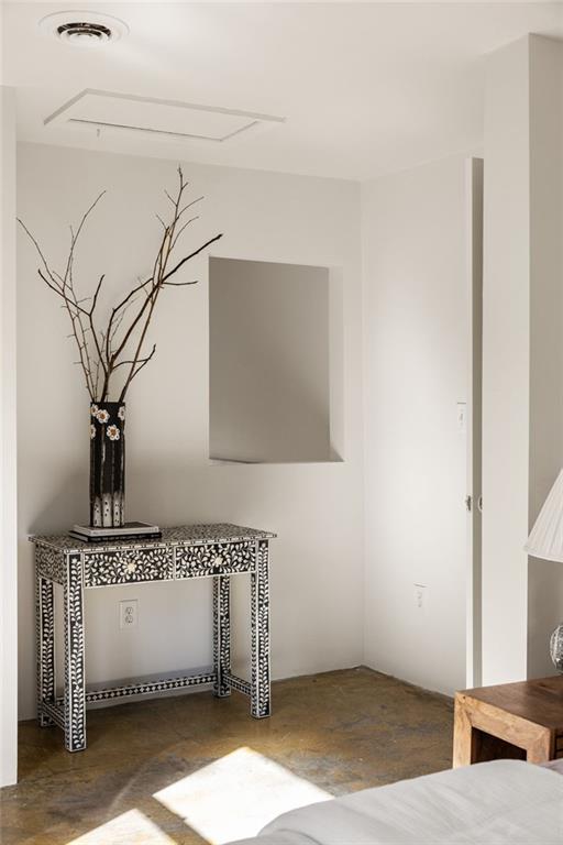 Interior corner with ornate console table, tall branches, and sunlight across the floor.