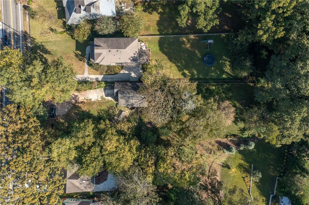 Aerial view of homes and leafy yards, with a trampoline in one backyard.
