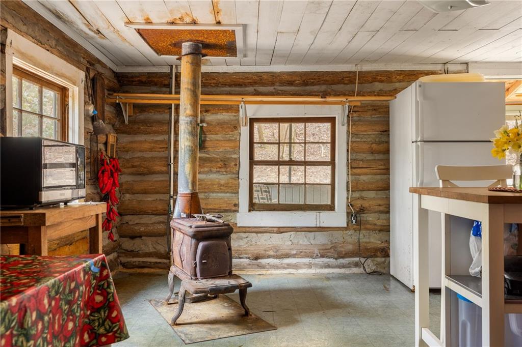 Rustic log cabin kitchen with a wood-burning stove and exposed log walls