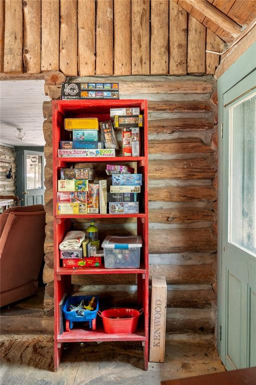 Rustic cabin interior with a red shelf of board games beside a pale blue door.