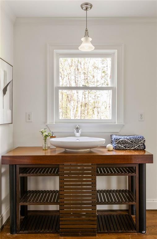 Bathroom vanity with a white vessel sink, open wood shelves, and a large window above.