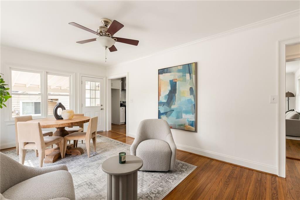 Furnished living and dining room with hardwood floors, a wood table, and abstract wall art.