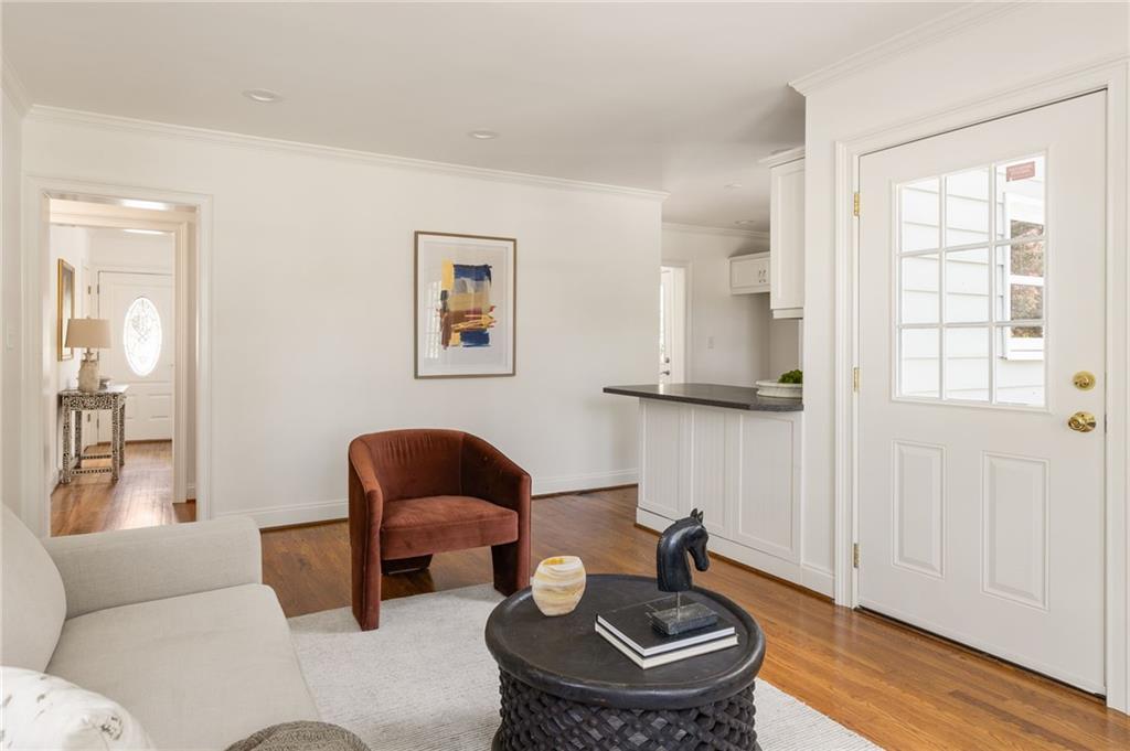 Living room with hardwood floors, a cream sofa, and a glass-paneled exterior door.