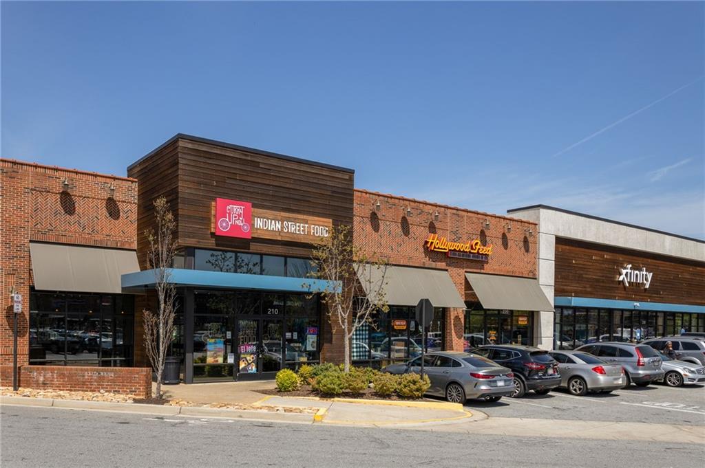 Shopping plaza with Indian Street Food, Hollywood Feed, and Xfinity storefronts.