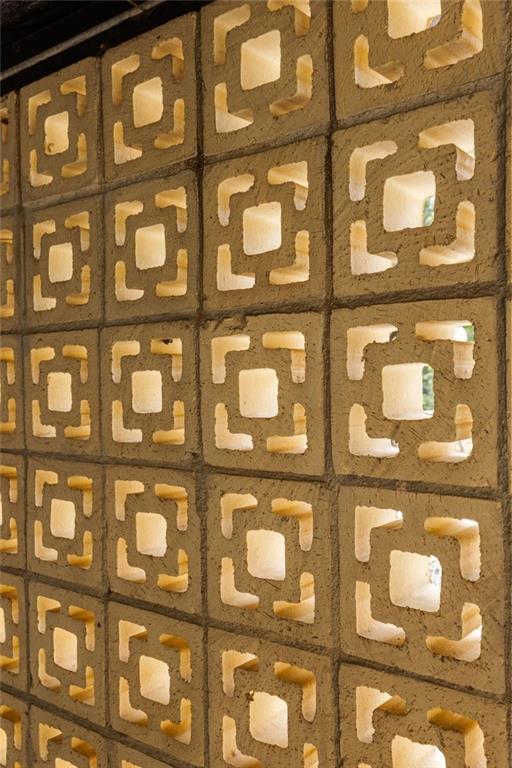 Patterned concrete block wall with geometric openings and warm light.