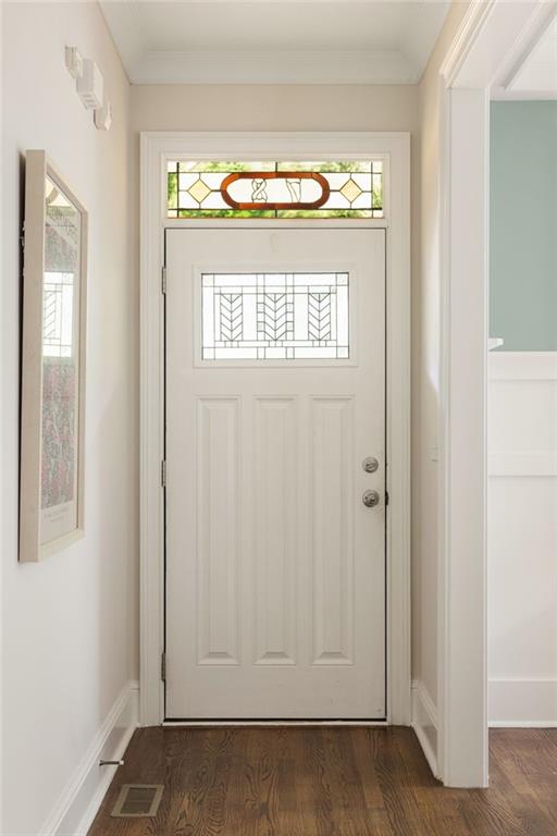 Front entry with a white door featuring geometric glass panels and a stained-glass transom.