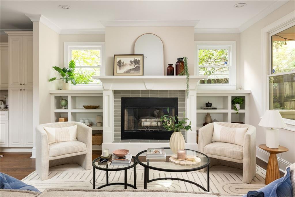 Living room with a central fireplace, built-in shelves, and two upholstered armchairs.
