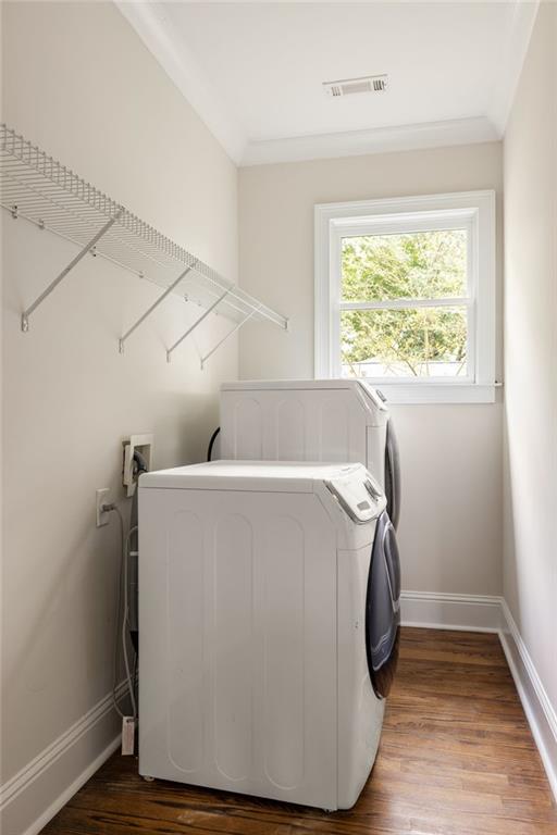 Laundry room with white washer and dryer, wire shelving, and a sunlit window.