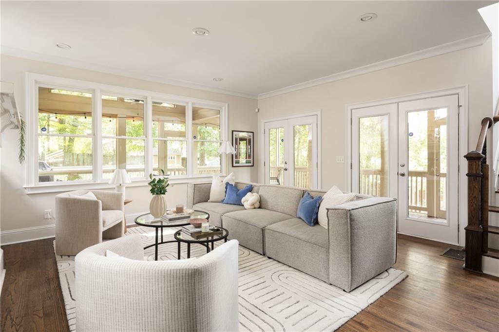 Living room with a gray sectional, blue pillows, large windows, and glass doors to a covered deck.