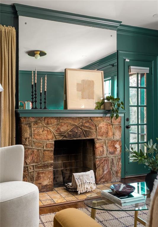 Living room with a rustic stone fireplace, deep teal walls, and a glass-paneled door.