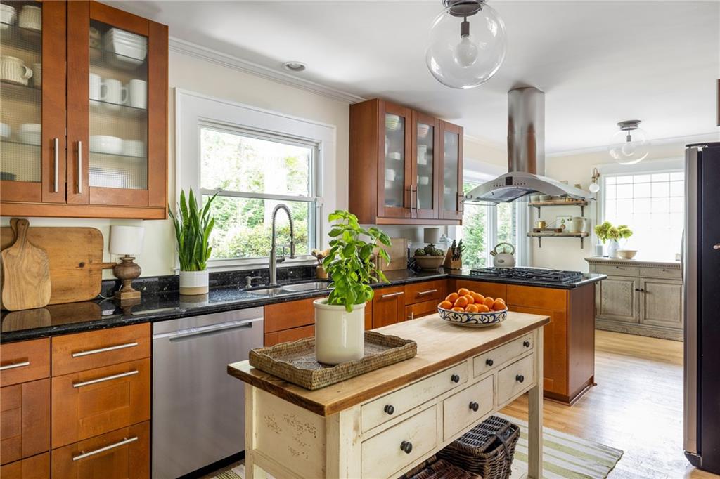 Kitchen with warm wood cabinets, a gas cooktop, and a central island with a butcher-block top.