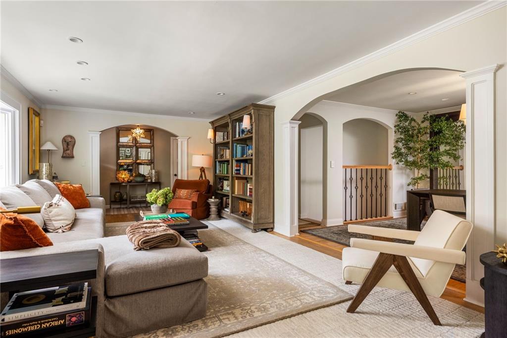 Living room with a large sectional, built-in bookcase, patterned rug, and arched openings.