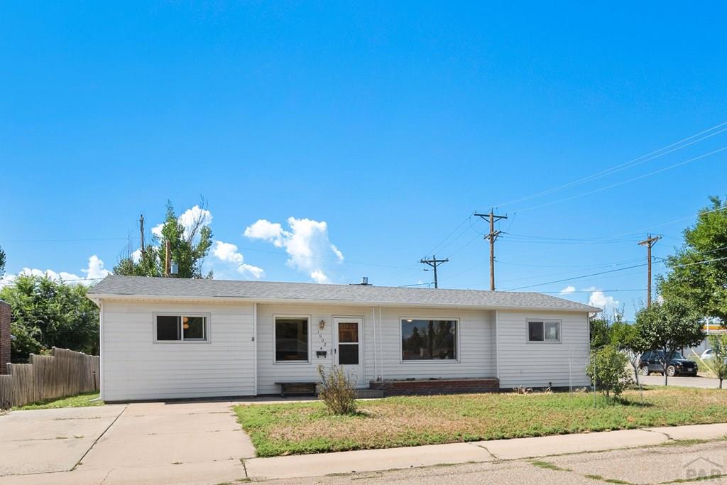 Single-story white-sided home with a long front façade and concrete driveway.