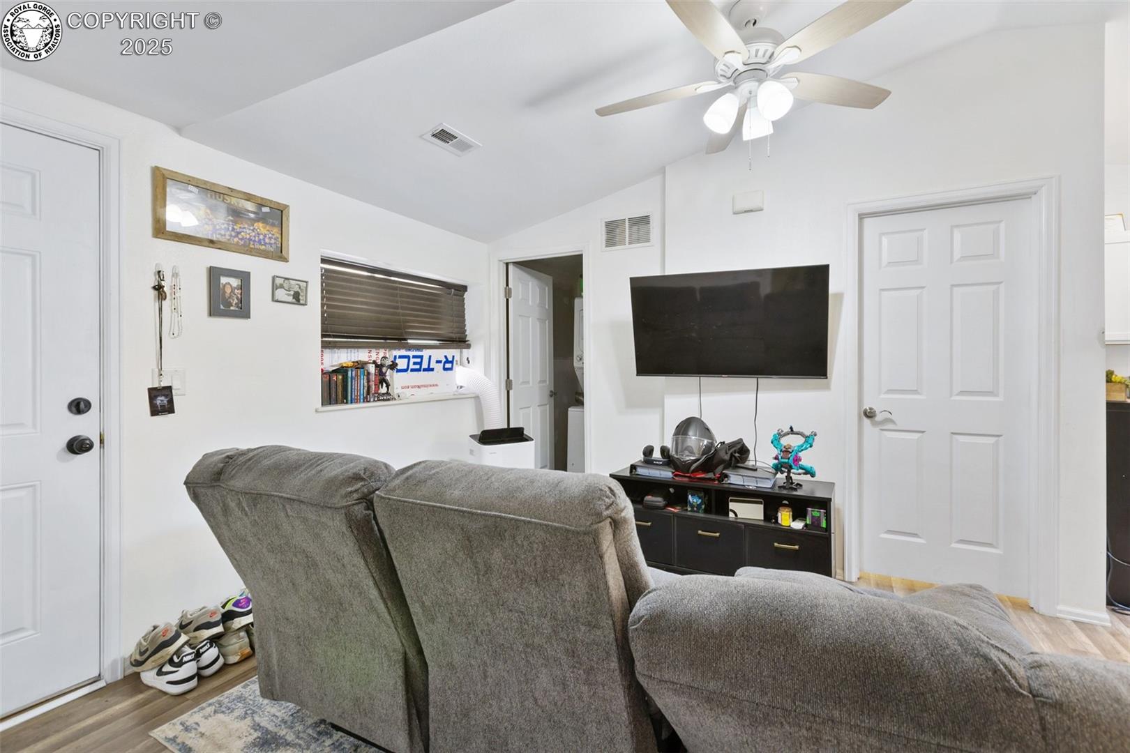 Living room with a gray reclining sectional facing a wall-mounted television and black media console.