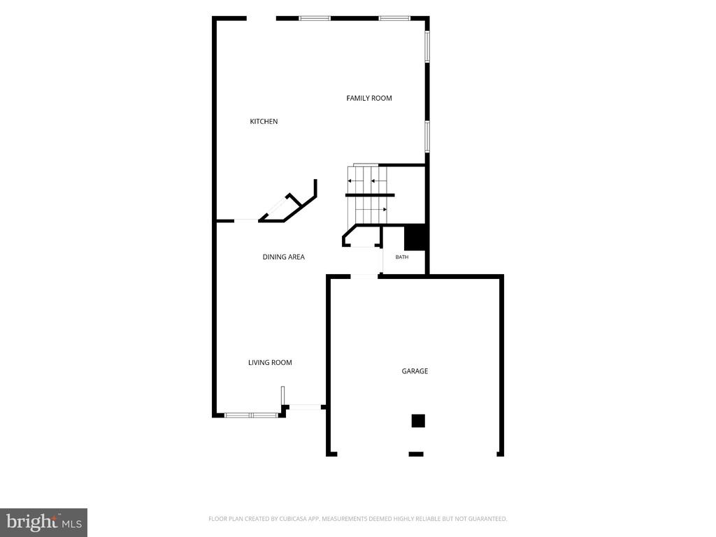 Floor plan showing kitchen, family room, dining and living areas, bath, staircase, and attached garage.