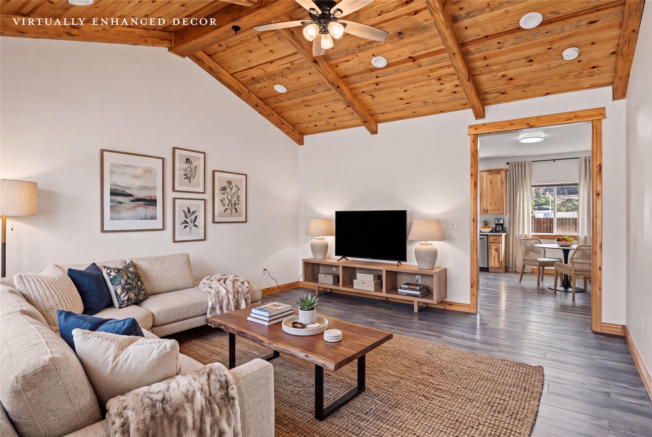 Living room with a vaulted wood ceiling, exposed beams, and a neutral sectional sofa.