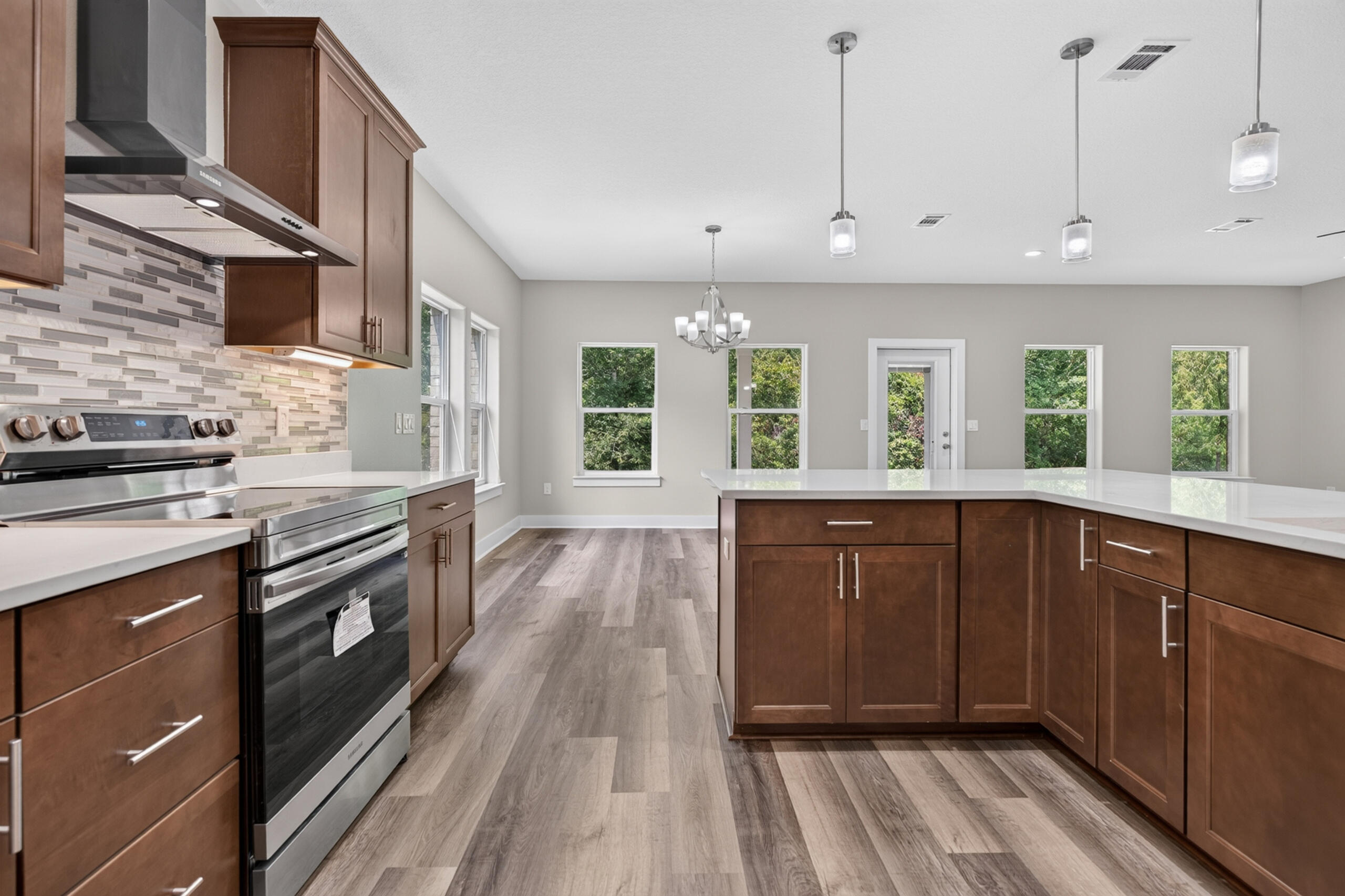 Spacious kitchen with a large white island, dark wood cabinets, and stainless steel appliances.
