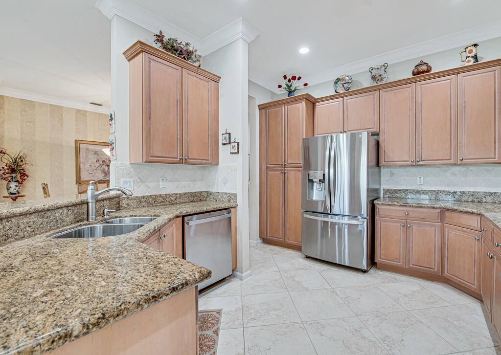 Kitchen with granite counters, warm wood cabinets, and stainless steel appliances.