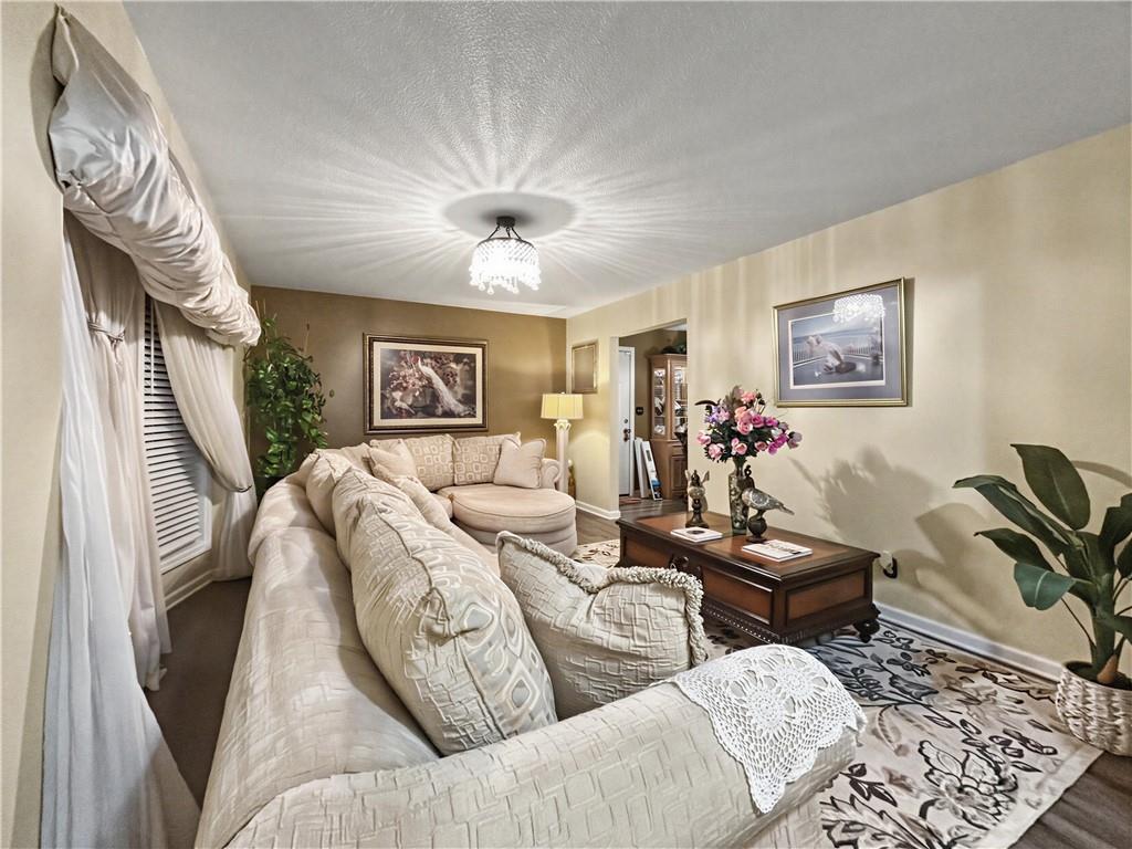 Furnished living room with a cream sectional, patterned rug, and chandelier.
