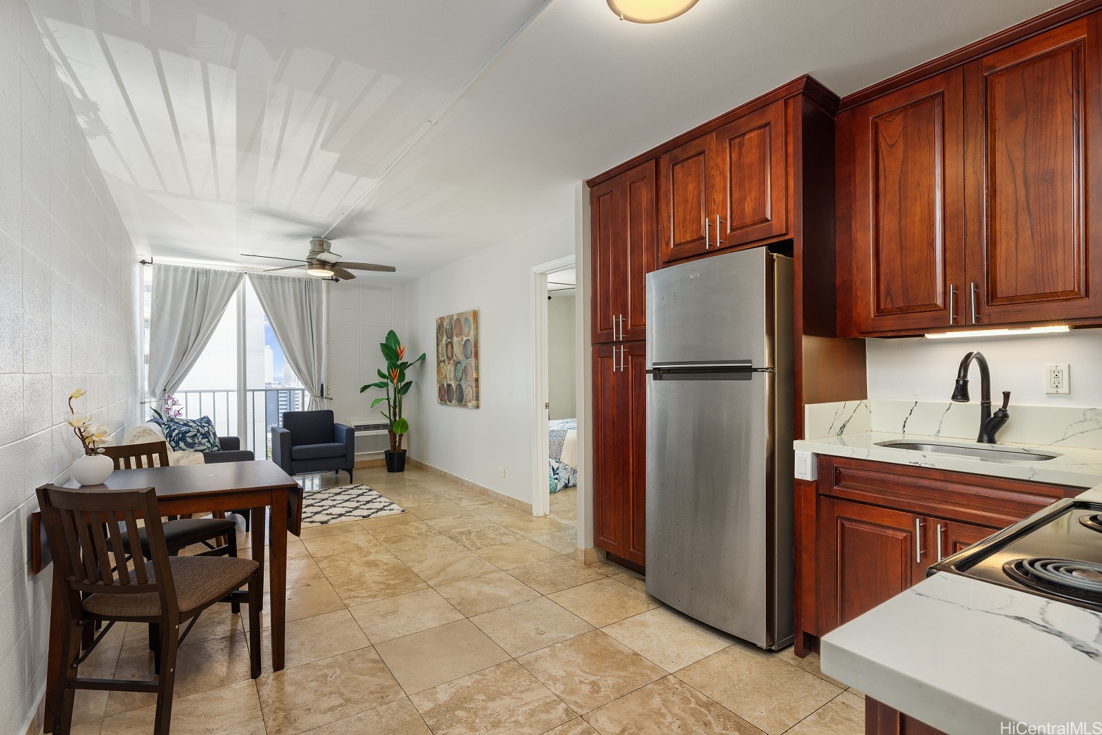 Open-plan kitchen and dining area with dark wood cabinets and a city view through sliding glass doors.