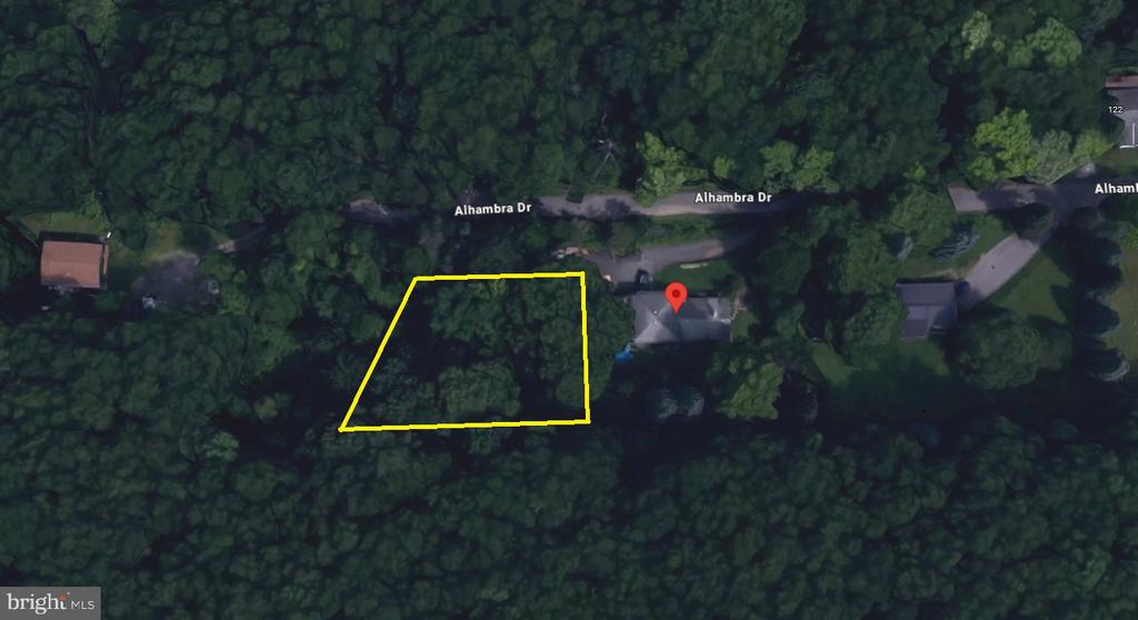 Wooded parcel outlined in yellow beside Alhambra Drive, viewed from above.