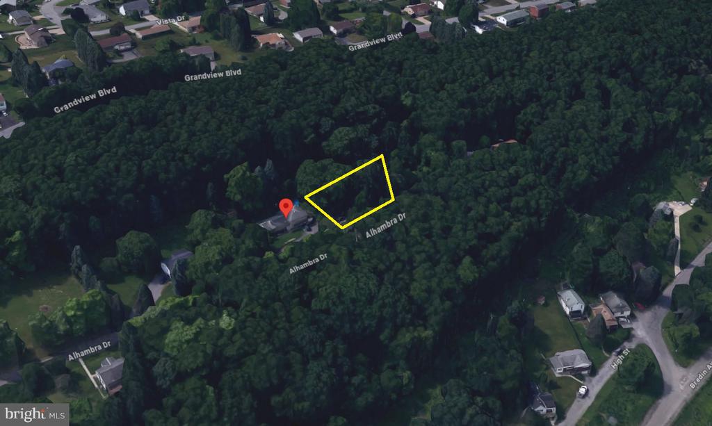 Wooded parcel outlined in yellow along Alhambra Drive, with a nearby red map pin.