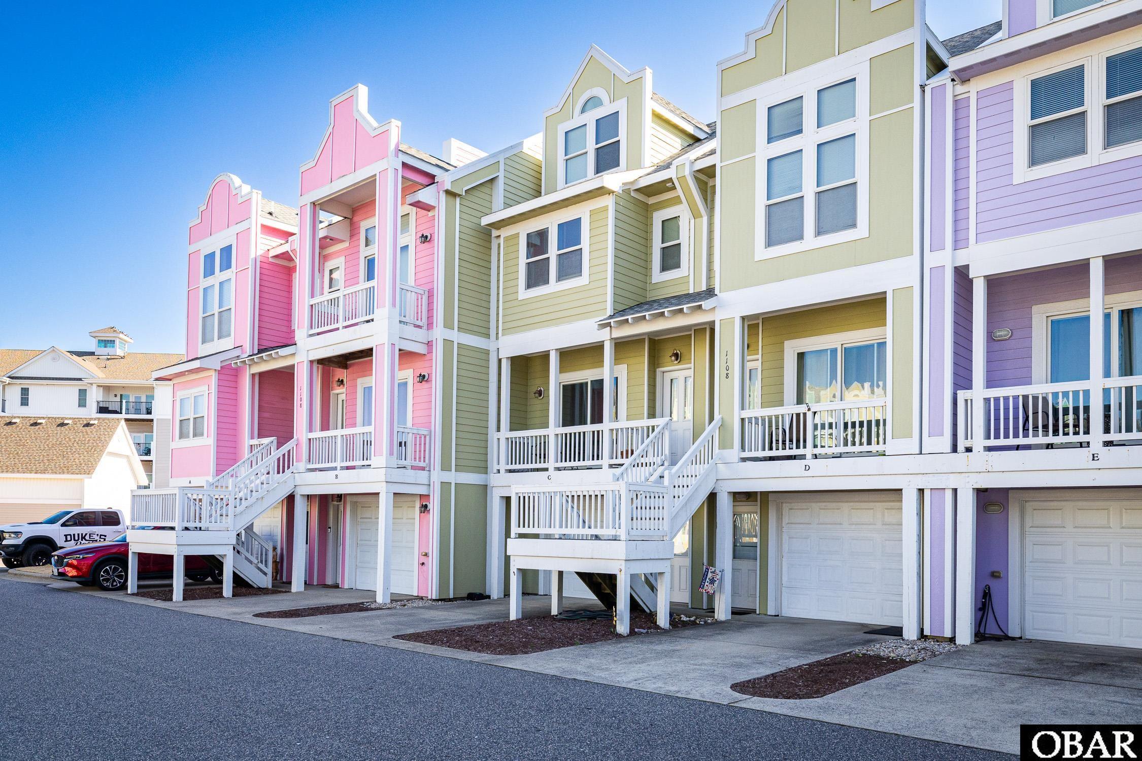 Pastel townhome row with white porches and stairs, including the green unit marked C.