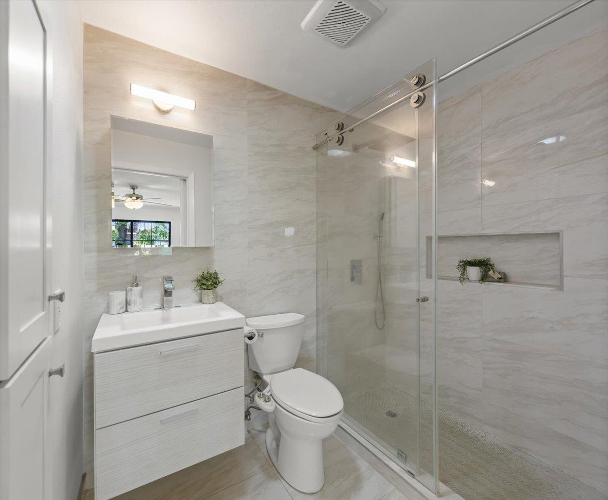 Modern bathroom with a floating vanity and glass-enclosed shower with a recessed niche.