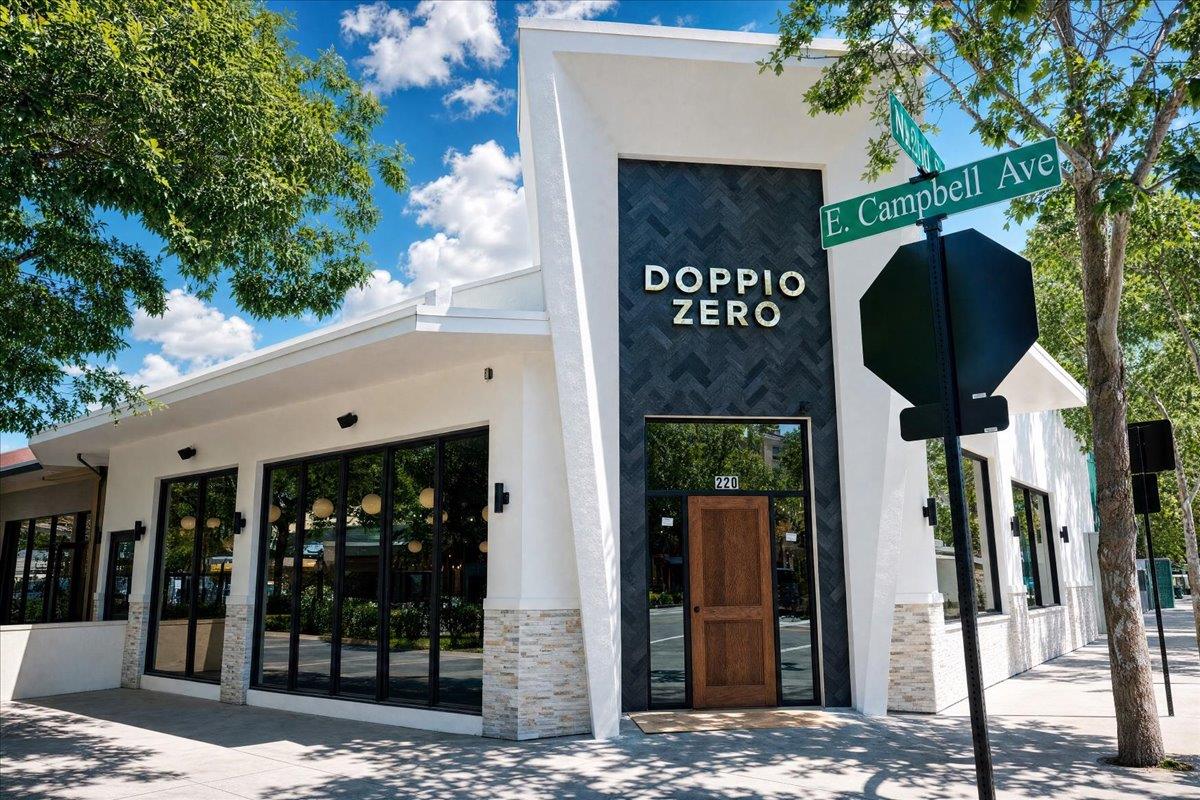 Modern white storefront with a dark Doppio Zero entrance facade and an E. Campbell Ave street sign.