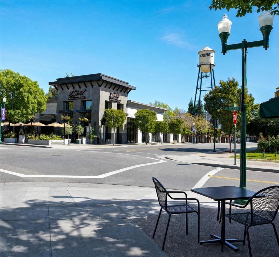 Downtown Campbell street corner with a meat market, water tower, and outdoor café seating.