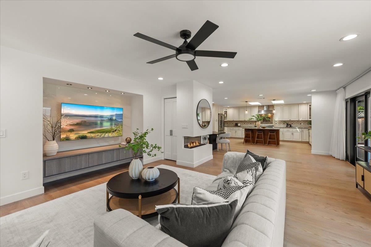 Open-plan living room and kitchen with a white sofa, linear fireplace, and kitchen island.